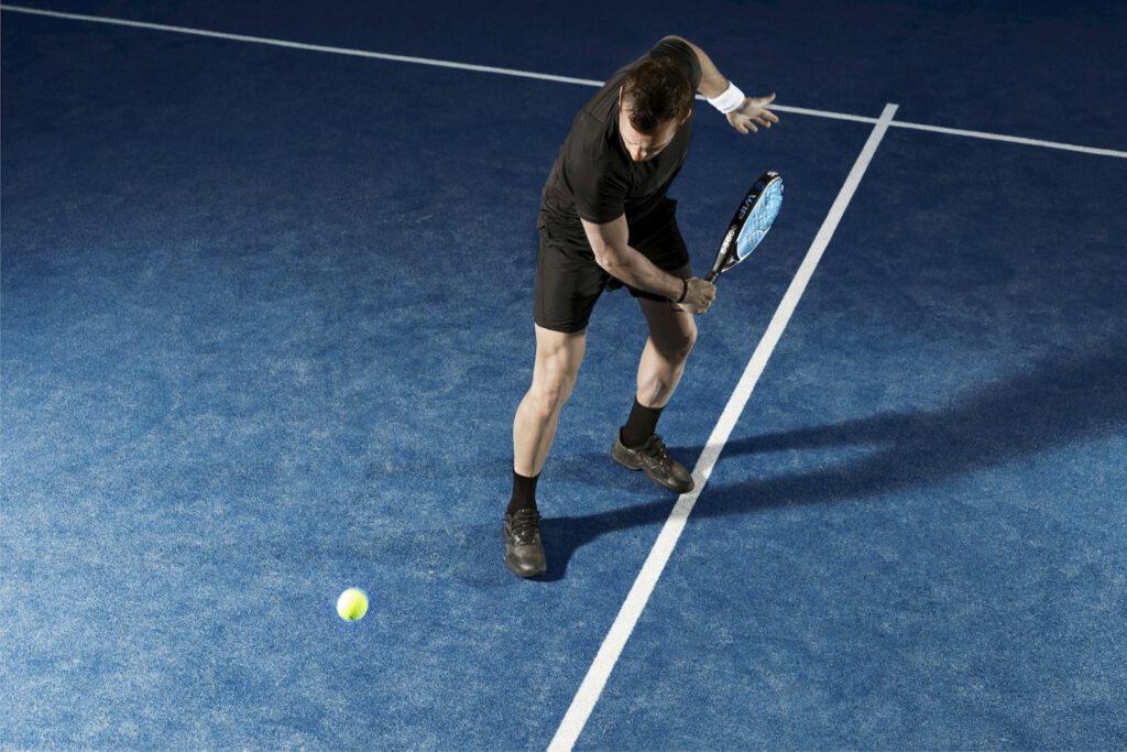 a man holding a padel racquet on a padel court