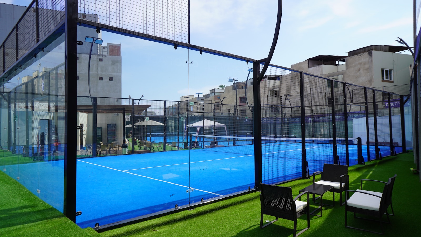 a padelcourt with chairs and tables on the grass